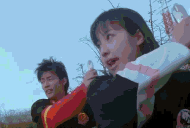 a man and a woman are standing next to each other and the man is wearing a red shirt with the letter l on it