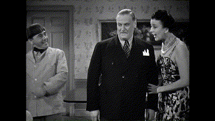 a man in a suit and tie stands next to a woman in a floral dress