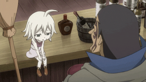a little girl sits on a wooden table next to a man and a bottle of whisky