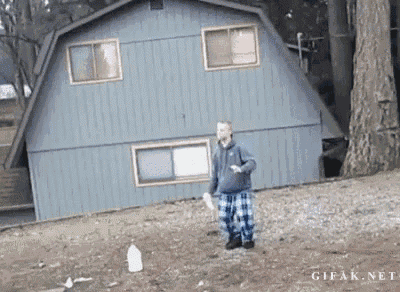 a man is throwing a bottle of milk in front of a blue house ..