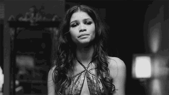 a black and white photo of a woman in a very revealing dress .