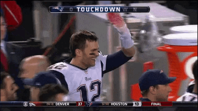 a man in a patriots jersey holds up his hand in the air