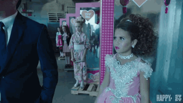 a little girl in a pink dress is standing next to a man in a suit
