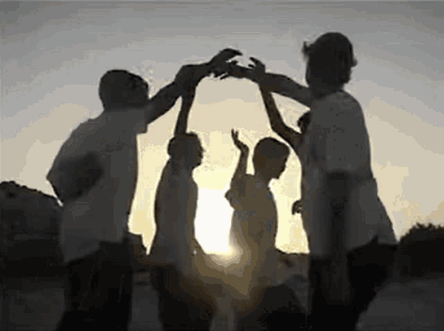 a group of people are standing in a circle giving each other a high five