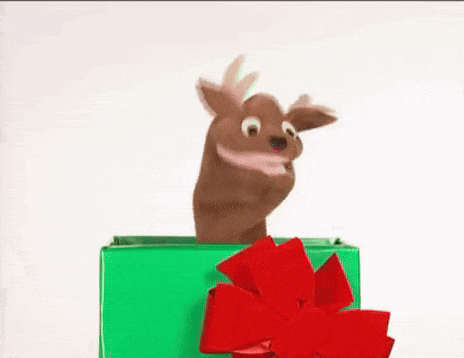 a reindeer puppet is sticking its head out of a christmas present .
