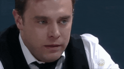 a close up of a man wearing a white shirt and black tie .