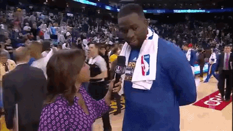 a man with a towel around his neck is being interviewed by a female reporter