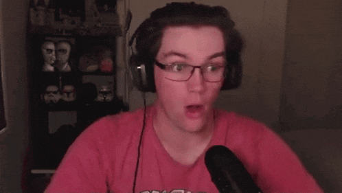 a man wearing glasses and headphones is screaming into a microphone