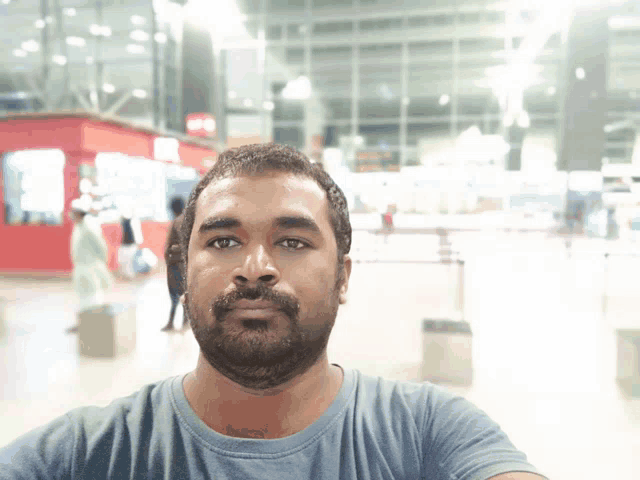 a man with a beard is taking a selfie