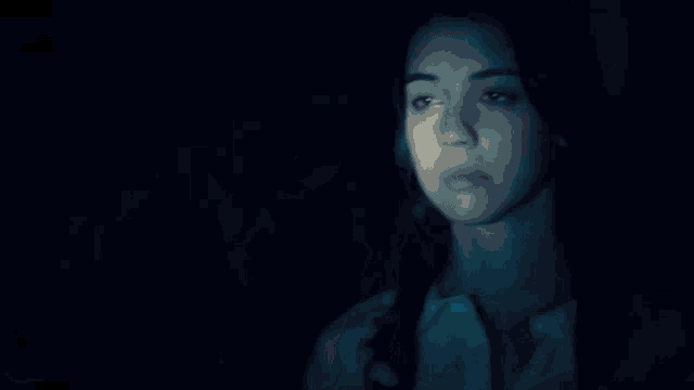 a man and a woman are kissing in the dark in a blurry photo .