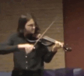 a man is playing a violin in a dark room