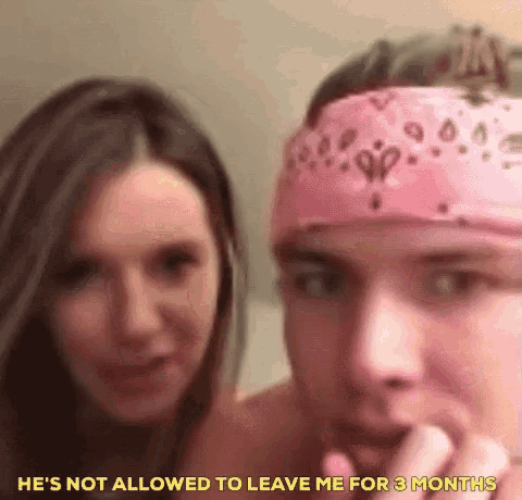 a man wearing a pink bandana is talking to a woman .
