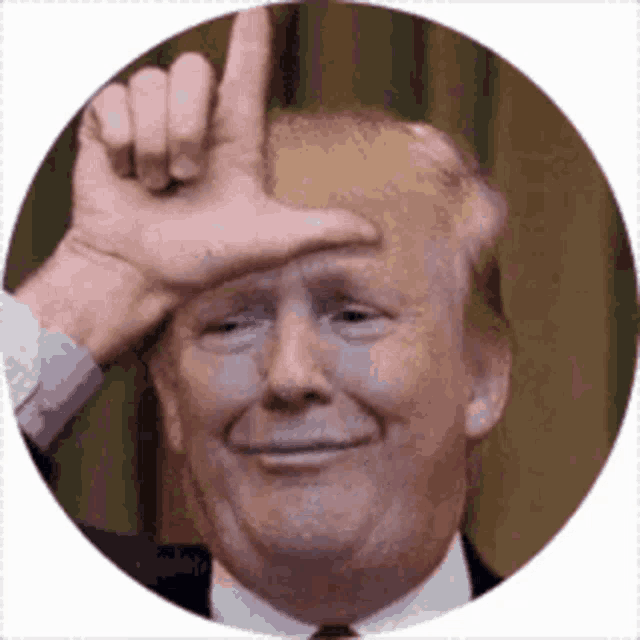 a man in a suit and tie is making a funny face with his hand on his forehead .