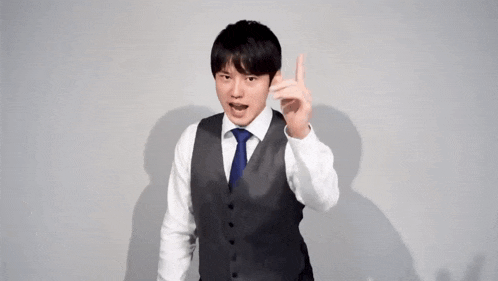 a man in a suit and tie is standing in front of a white wall