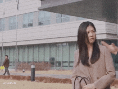 a woman standing in front of a building with the hashtag jsmssom on the bottom