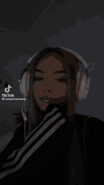 a woman wearing headphones has a tiktok icon on her face