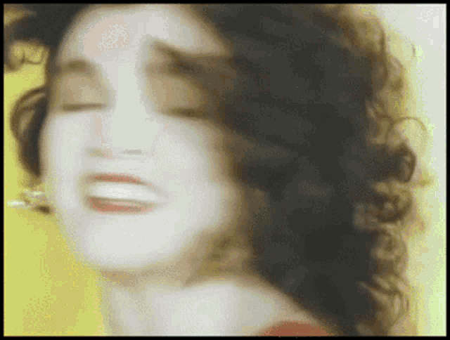 a blurry picture of a woman 's face with a yellow background