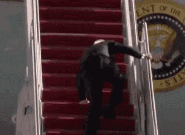 a man is walking up a set of red stairs .