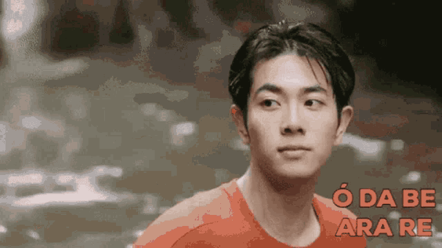 a man in a red shirt is looking at the camera with the words o da be ara re written in red .