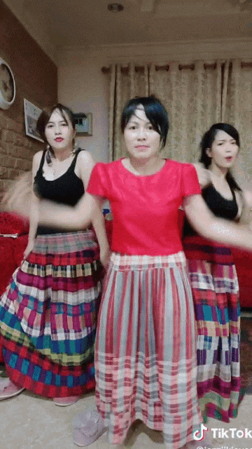 a woman in a red shirt is dancing with other women