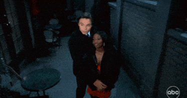 a man and a woman are hugging in a hallway with a abc logo