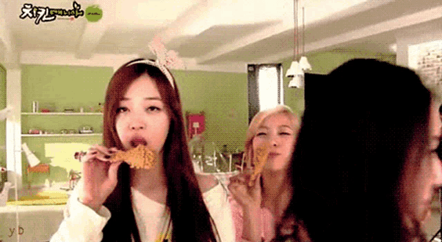 a girl eating a piece of food with the word yd on the bottom right corner