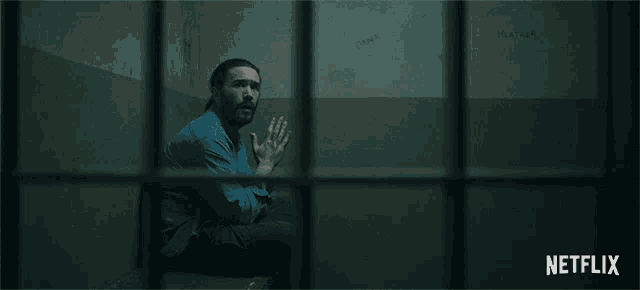 a man sits in a jail cell with the words no on the bottom
