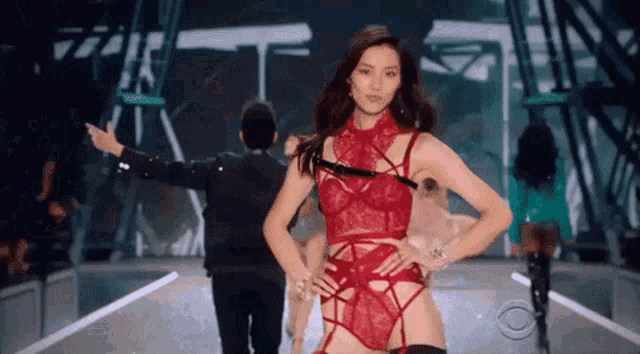 a woman is walking down a runway at a fashion show .