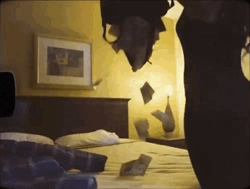 a person is standing on a bed in a hotel room