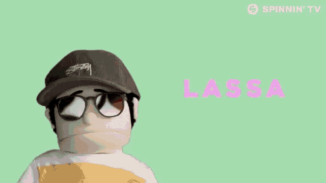 a puppet wearing sunglasses and a hat is screaming with the word lassa behind him .