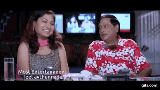 a man and a woman are sitting next to each other in front of a screen that says most entertainment feel avthunnadu ..