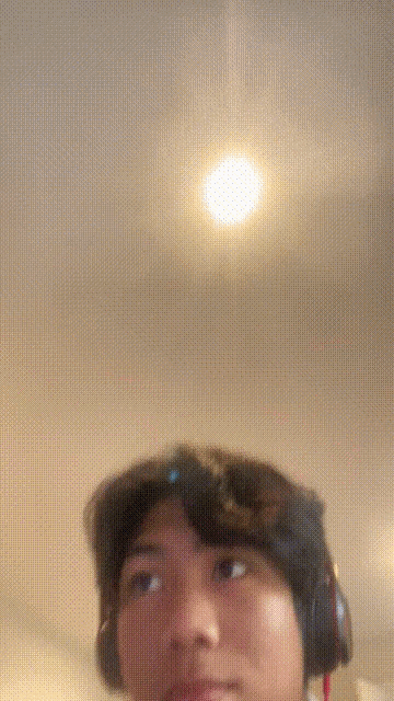 a person wearing headphones looks up at a light
