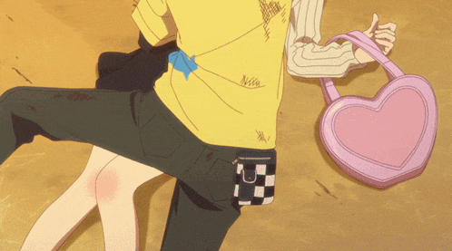 a pink heart shaped purse is on the ground next to a person