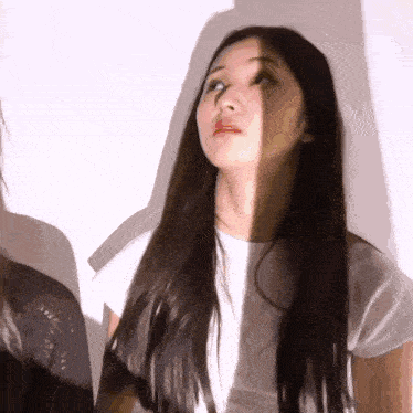 a woman with long hair is looking up at something