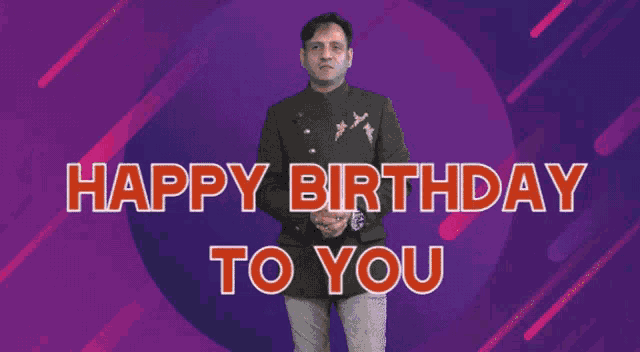a man is standing in front of a purple background with the words happy birthday to you