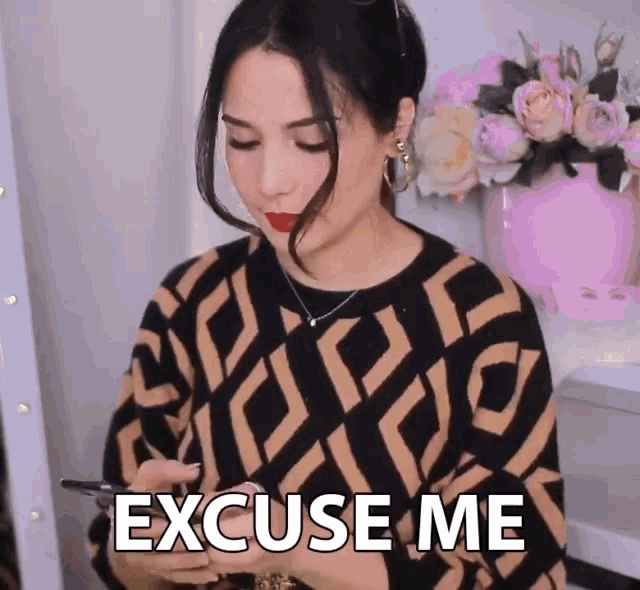 a woman holding a cell phone with the words excuse me on her shirt