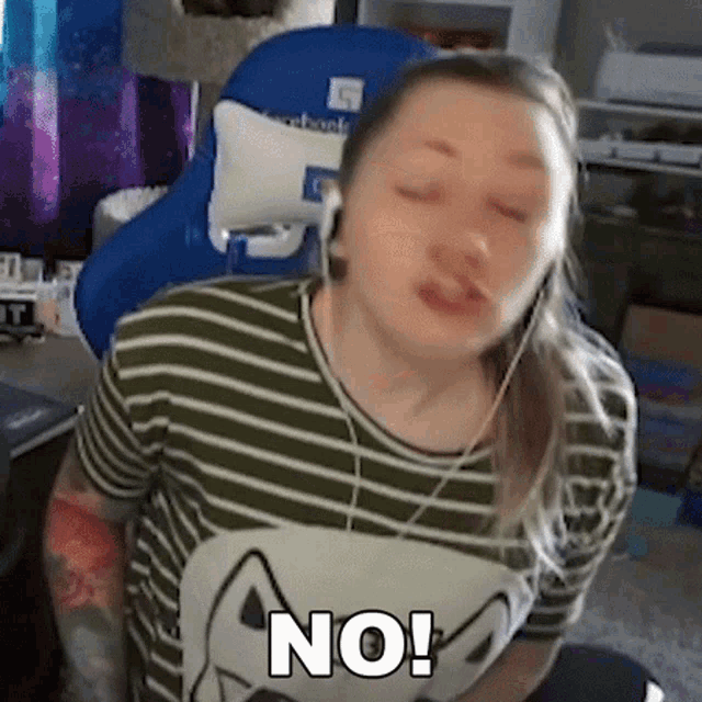 a woman wearing headphones and a striped shirt with a cat on it says no