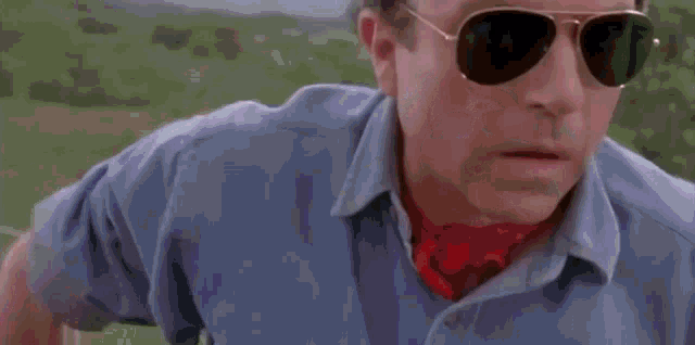 a man and a woman are sitting in a car . the woman is wearing sunglasses .