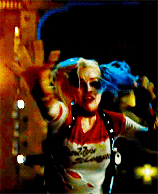a woman in a harley quinn outfit is giving the middle finger