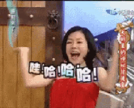 a woman in a red dress is flexing her muscles in front of a tv screen that says ' chinese ' on it