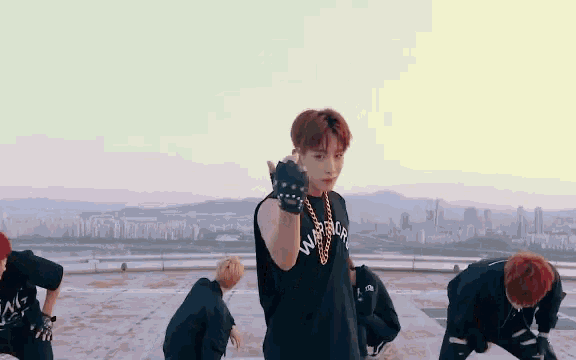 a group of young men are dancing on a rooftop in front of a city skyline