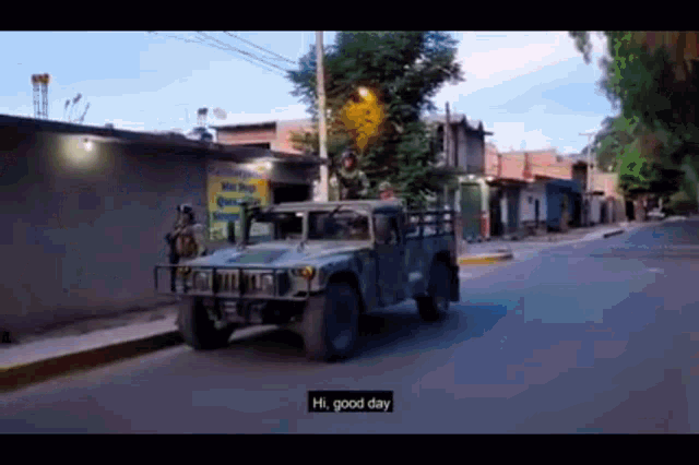 a military vehicle is driving down a street and says hi good day on the screen