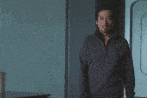 a man in a black jacket is standing in a doorway .