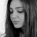 a black and white photo of a woman with long hair and her eyes closed .