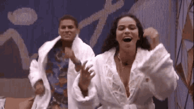 a man and a woman wearing bathrobes are dancing together .