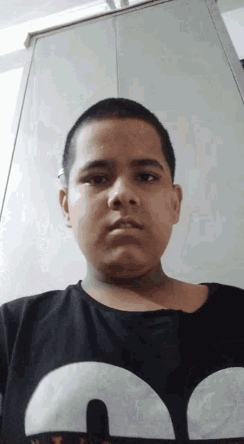 a young boy wearing a black shirt with a white letter n on it