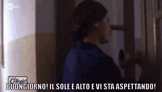 a man in a blue shirt is standing in front of a door and says buongiorno