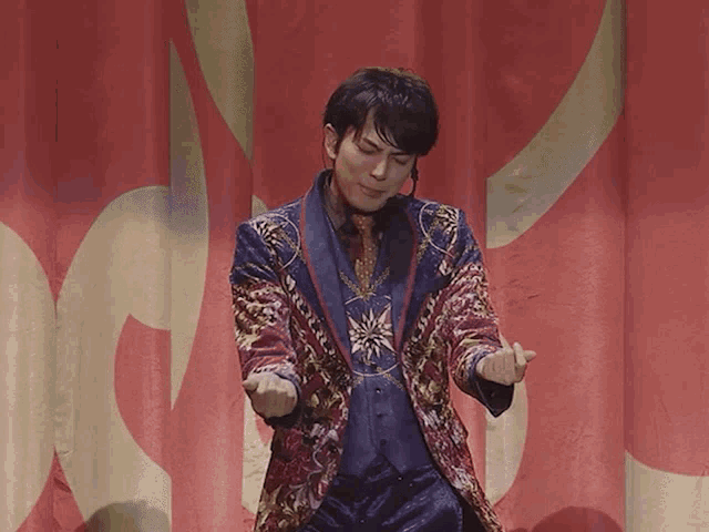 a man in a colorful suit is standing on a stage