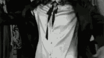 a black and white photo of a man wearing a white shirt and black tie