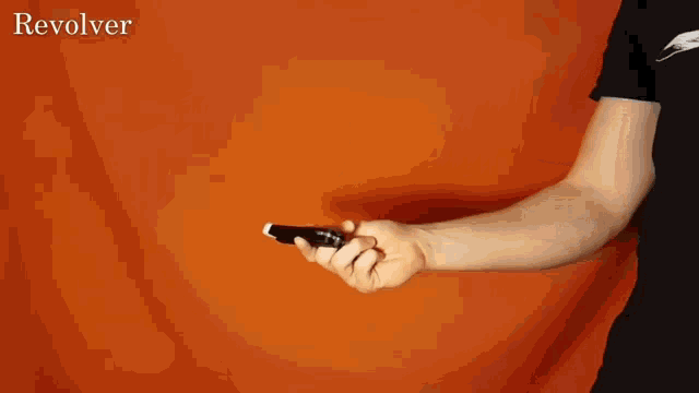 a person holding a revolver with the word revolver behind them
